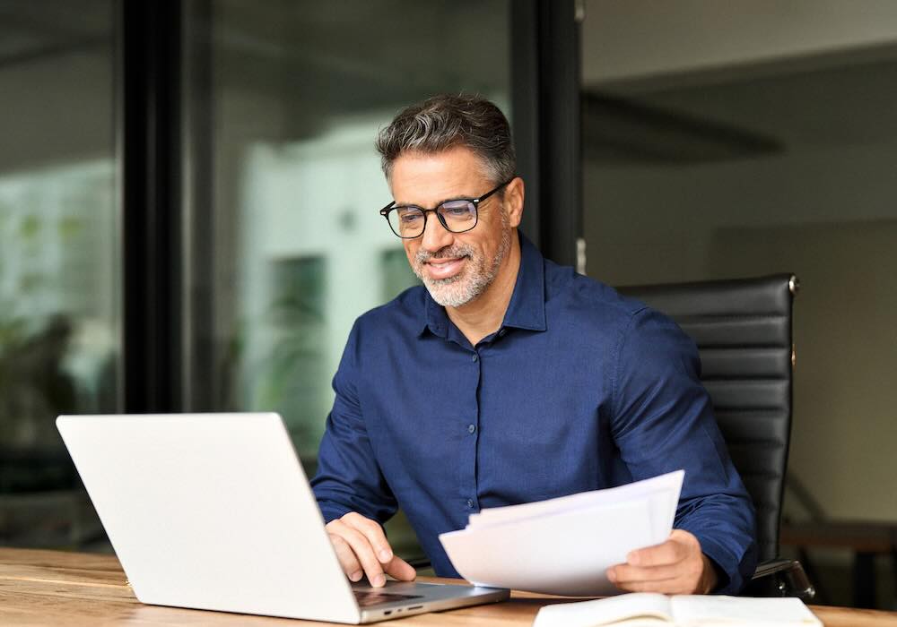 Businessman going through documents sitting in his office 