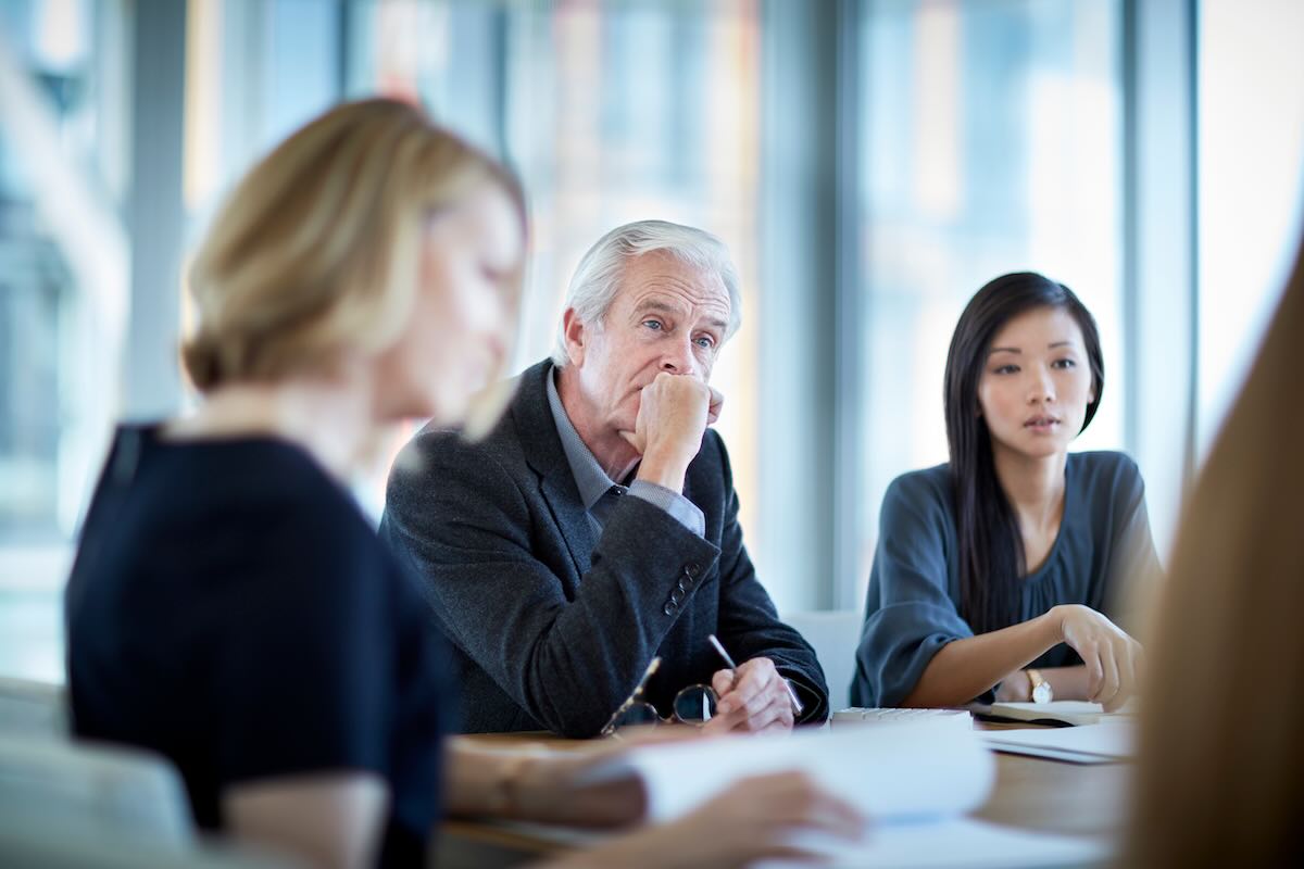 Business owner at meeting listening 